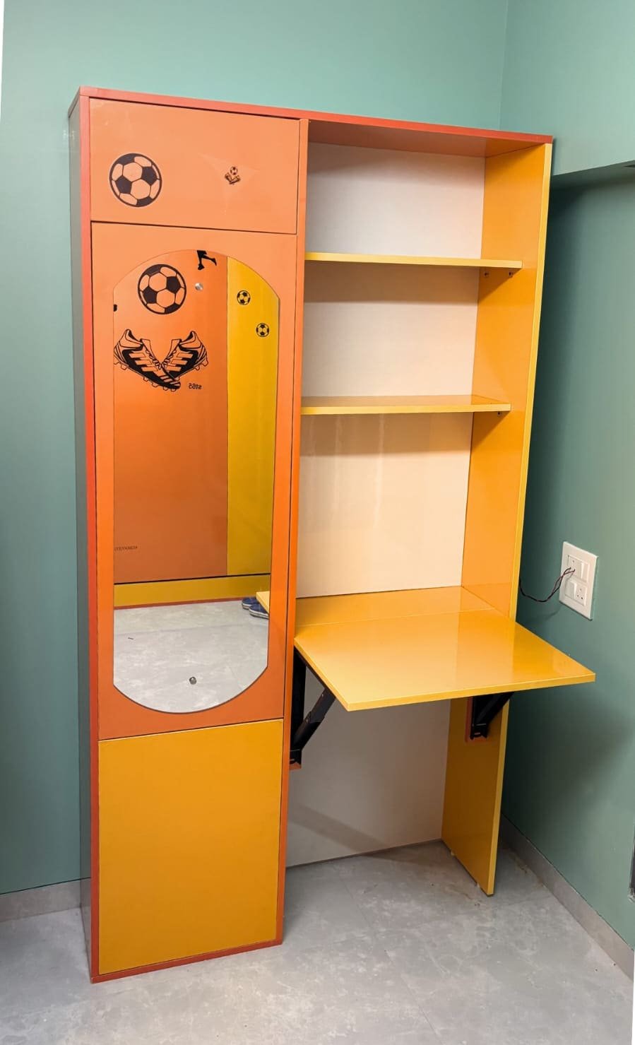 Standalone dressing and study module in orange and yellow laminate with a football theme, mirror, shelves and a fold-down desk.