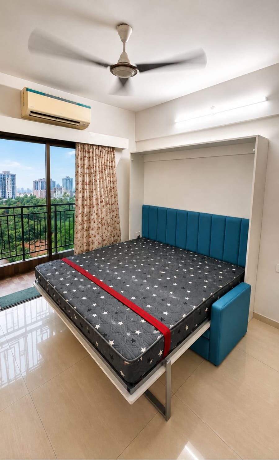 Night mode: the same white Dwalsbed folded down over the teal sofa, queen mattress ready, balcony and city view behind.